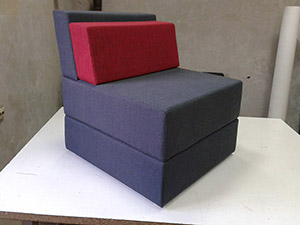plava fotelja sa crvenim jastukom
